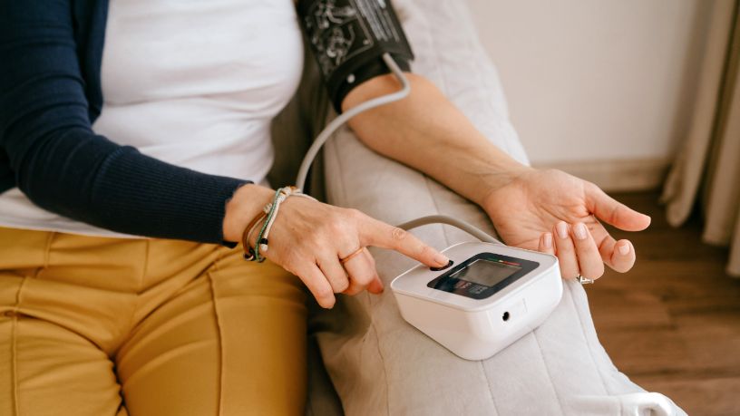 A person uses a blood pressure cuff