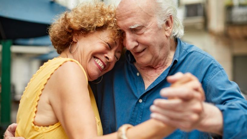 Older couple laughing and dancing.
