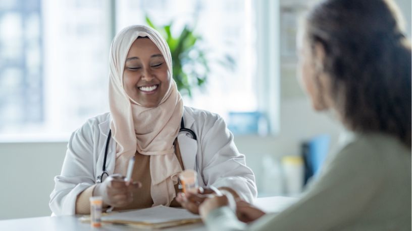 A doctor smiles with a patient.