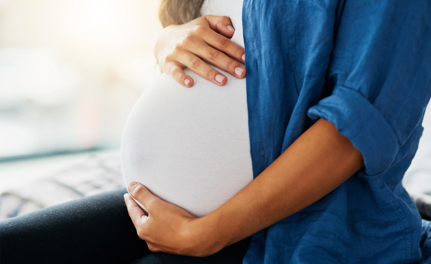 Pregnant women circling her arms around her belly