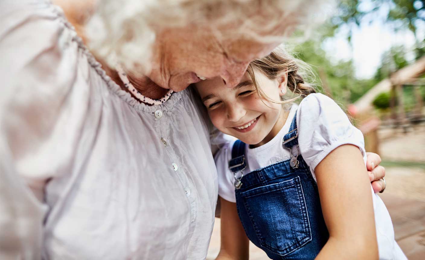 Smiling girl in an embrace with an old lady