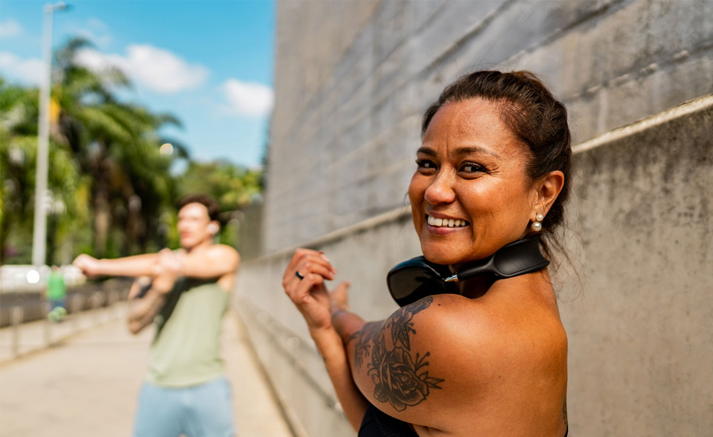 Middle aged woman and man doing arm and shoulder stretches