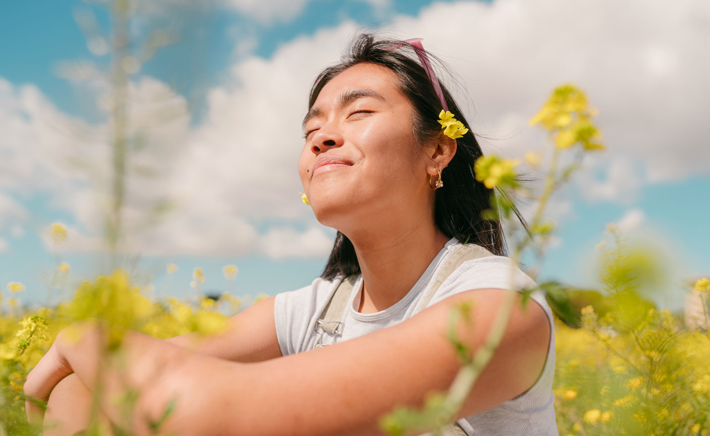 Girl sitting among yellow flowers