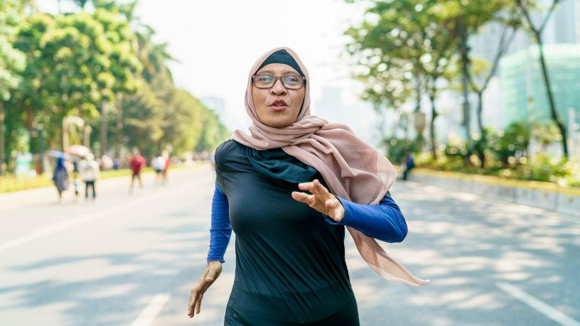 Woman runs determinedly on a sunny day.