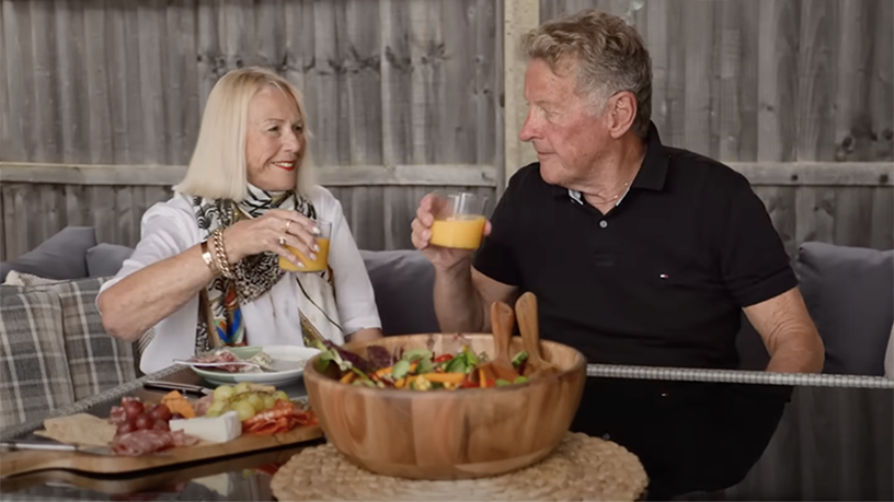 Greg and his wife having a glass of orange juice together.