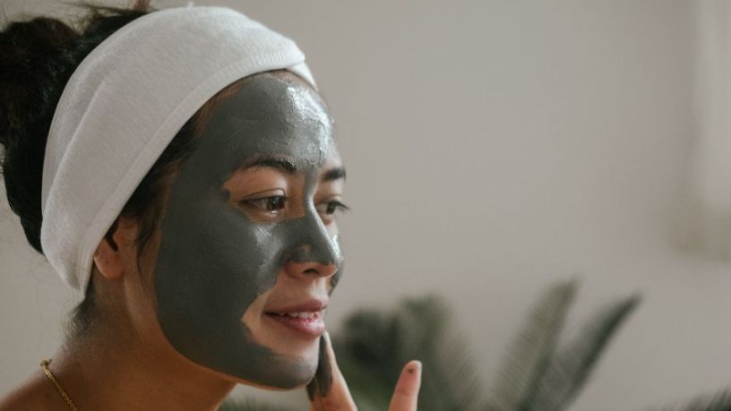 Woman wearing a white headband and green facemask.