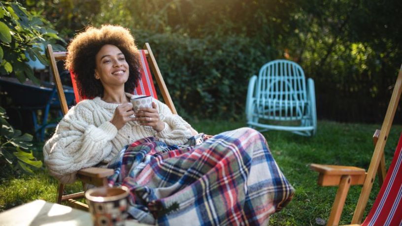 Woman sitting on a deckchair in a garden.