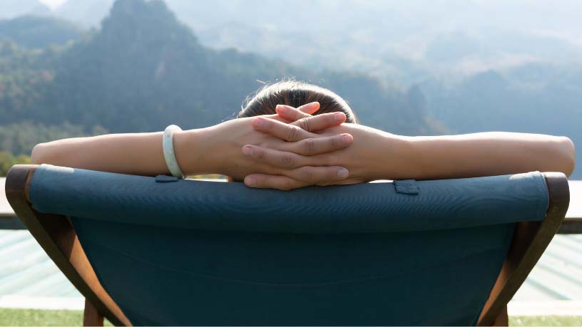 Person from behind sitting in a deckchair with a view