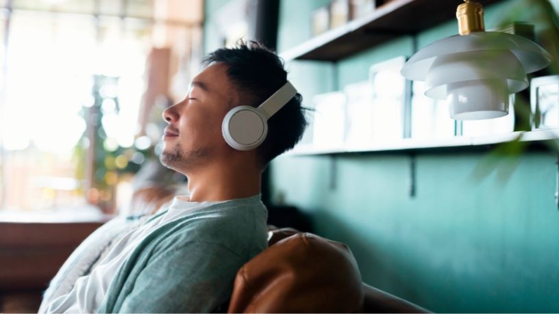 Seated man wearing headphones.
