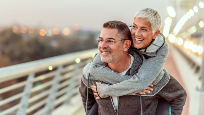 Man gives woman a piggyback.