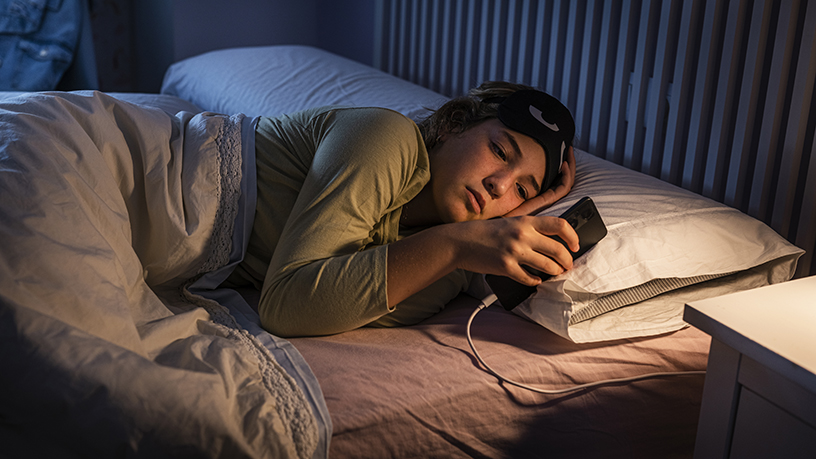 A person laying in bed looking at their phone.