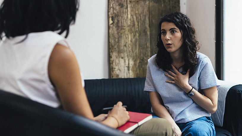 Two women sitting across each other having a conversation