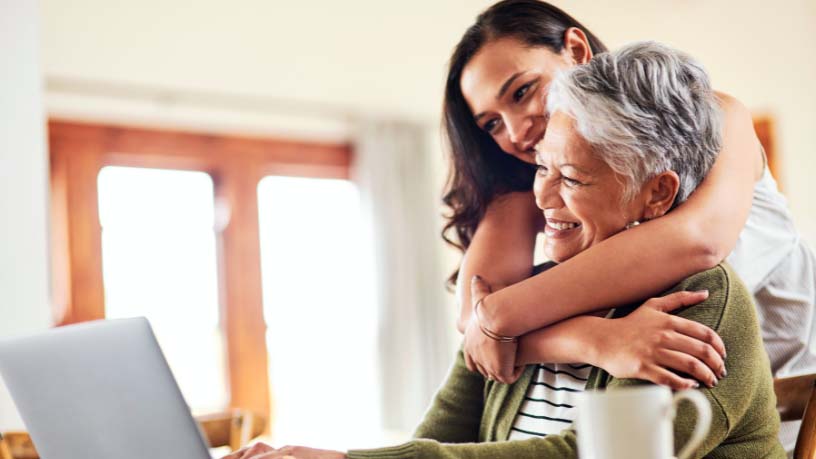A woman hugs her mum around her shoulders.