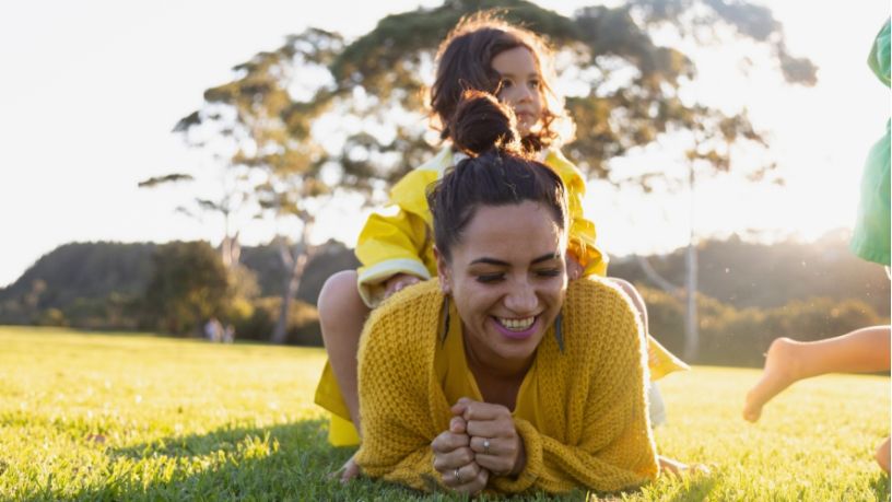 Daughter lies on mother’s back.