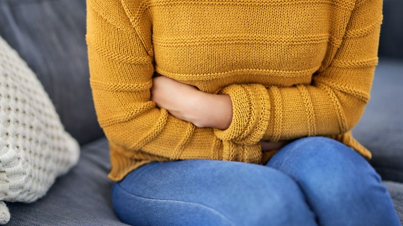 Woman holds her stomach in pain.