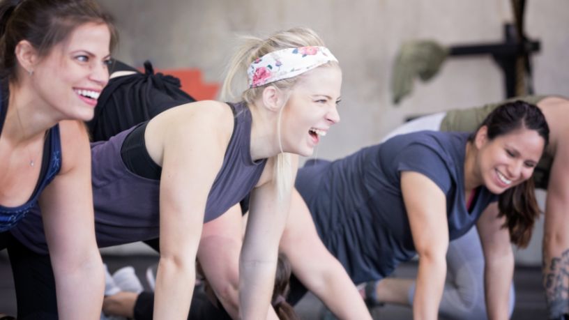 Young women smiling while exercising together.
