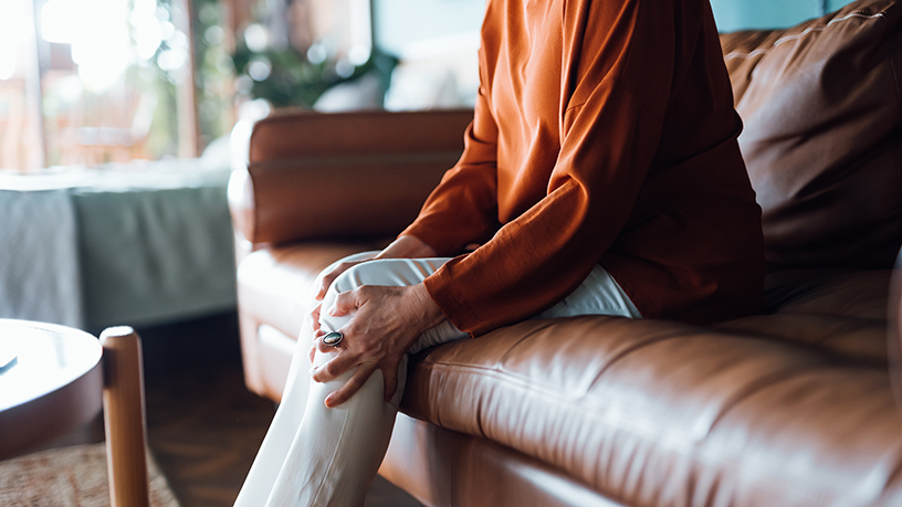 A close up of a person holding their knee.