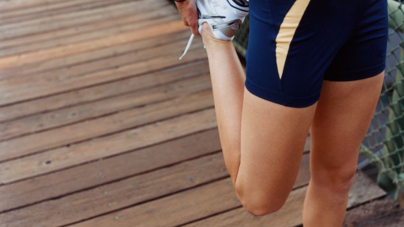 A woman stretches her knee.