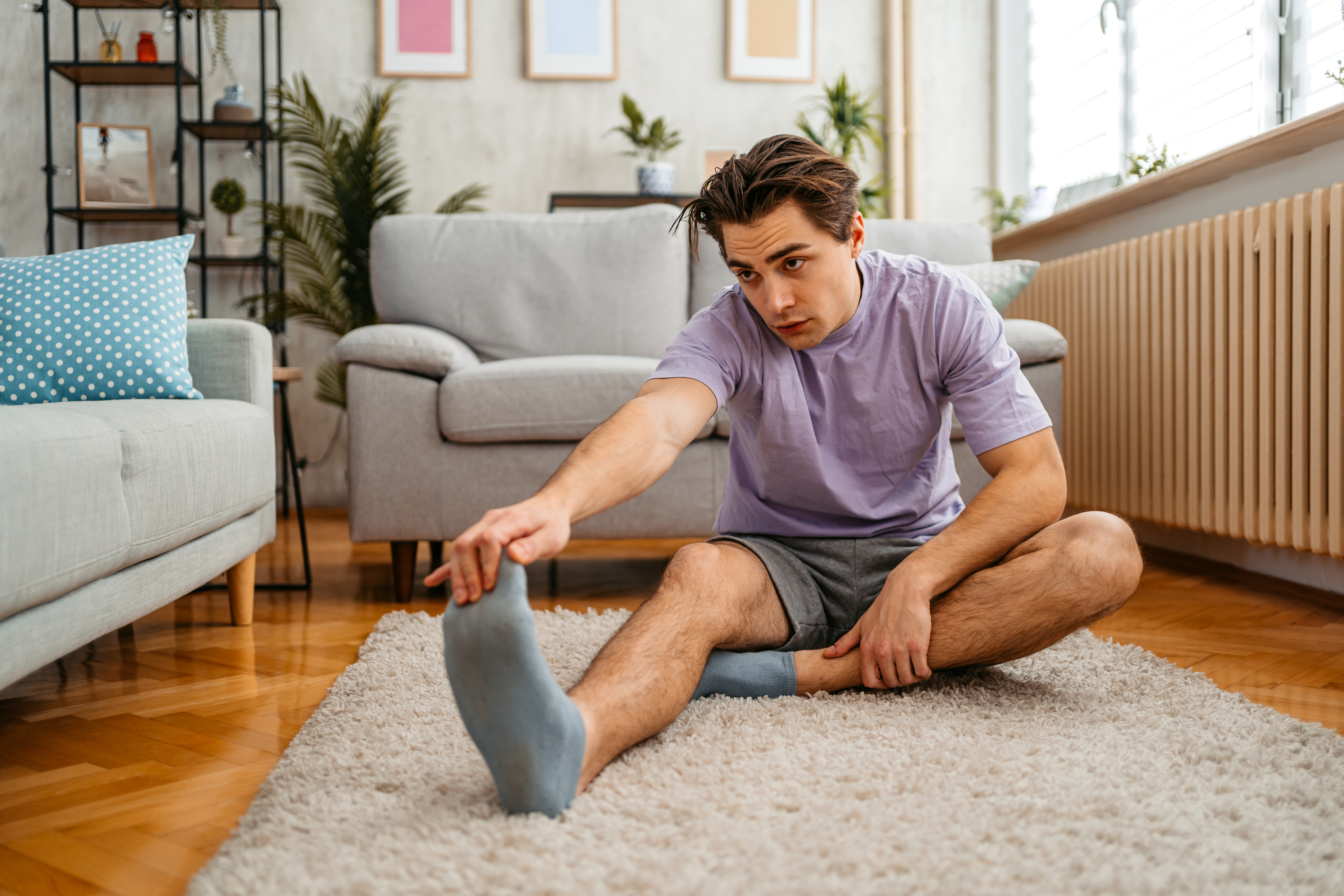 A younger man stretching his legs before a run
