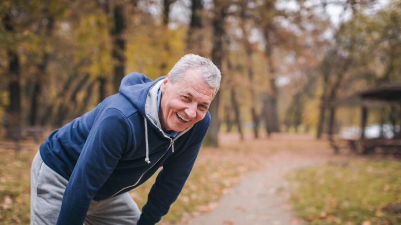A man resting while going for a run outside.