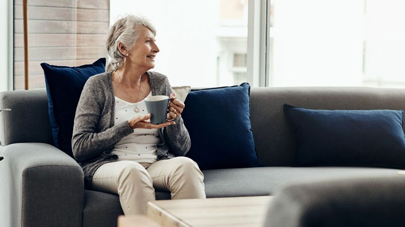 Elderly woman sitting to drink hot drink