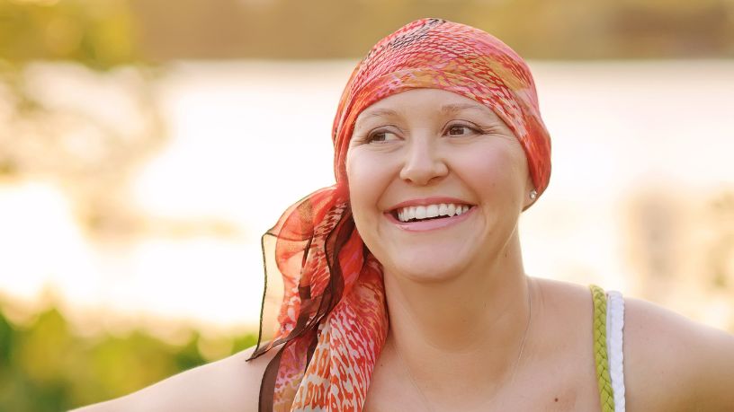 A woman wearing a headscarf smiles to the side of the camera.