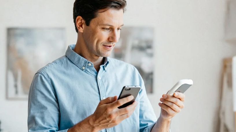 A diabetic man recording his blood glucose levels on his phone.
