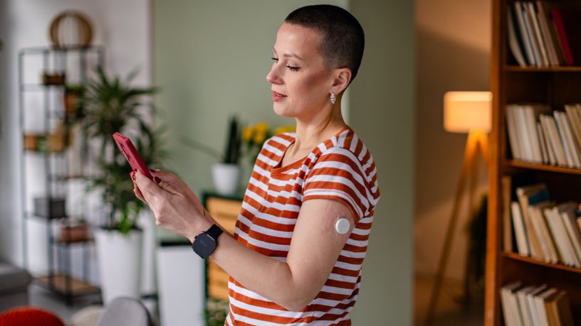 Young woman living with diabetes using technology for monitoring blood glucose levels