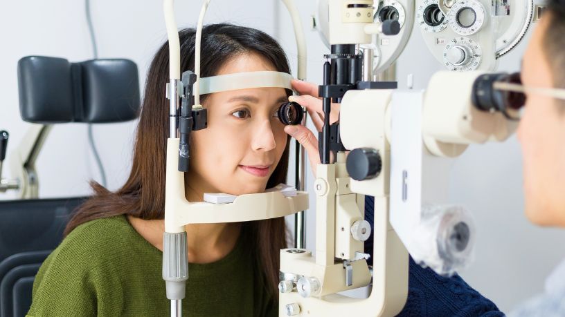 A woman has her eye checked by an optometrist.