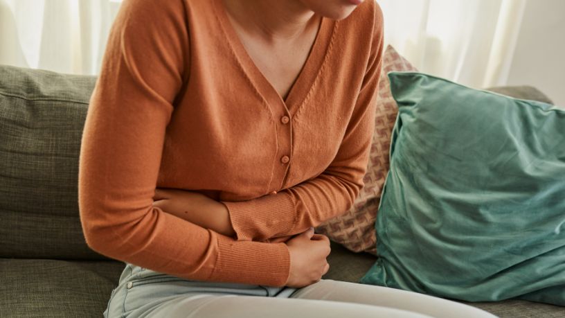A woman holds her stomach in pain