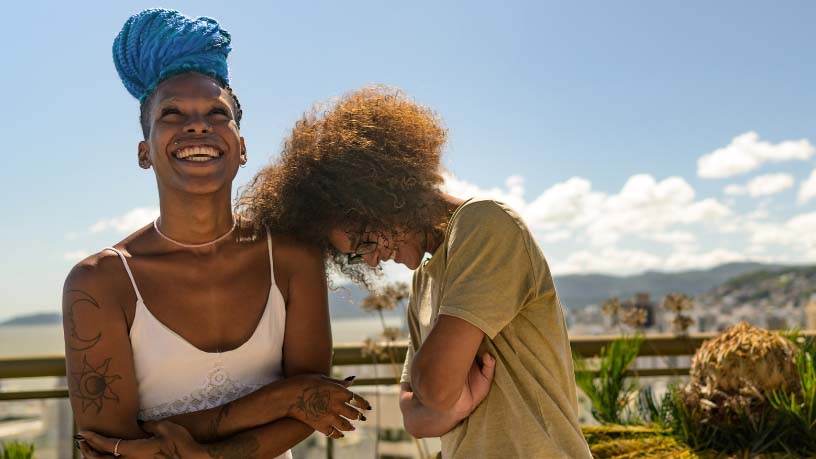 Friends laugh together in the sunshine.