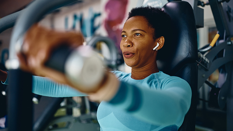 A woman lifting weights at the gym.