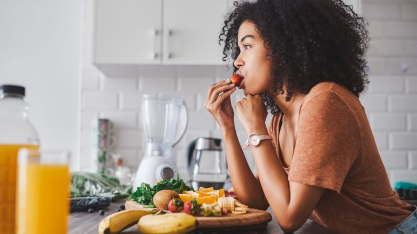 A woman eating a fruit platter
