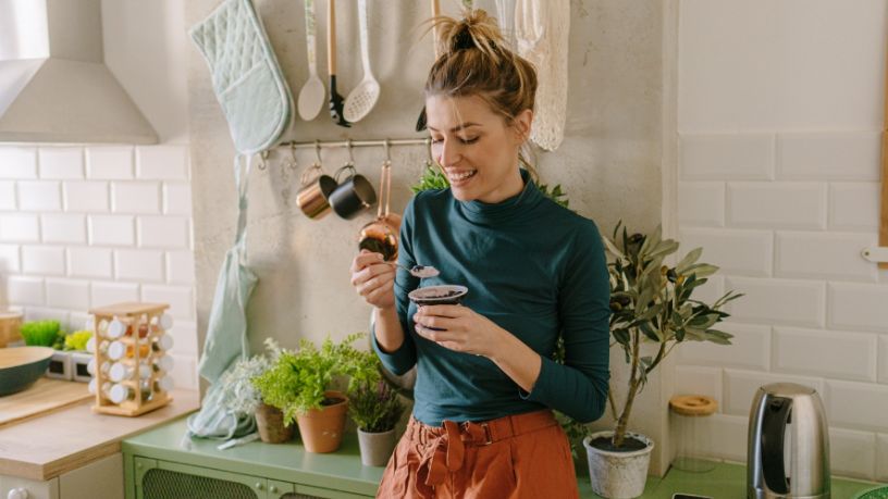 Woman in kitchen eating 