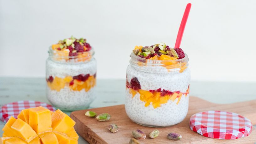 Two pots of raspberry and mango chia pudding sit side by side.