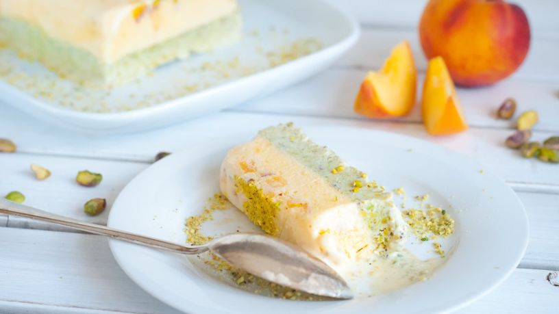 A light peach and green slice sprinkled with pistachio nut crumb