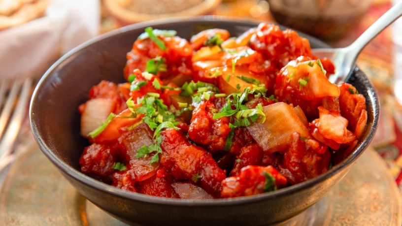 A bowl of chicken and vegetables sits on a table