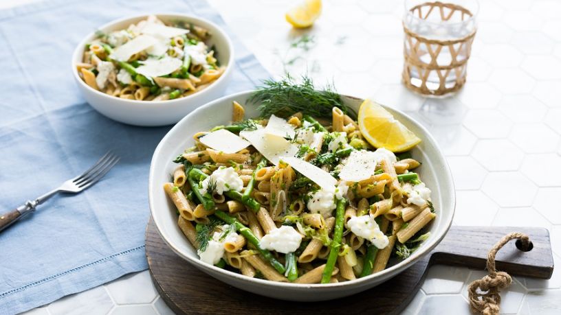 Two bowls of pasta primavera sit side by side on a table.