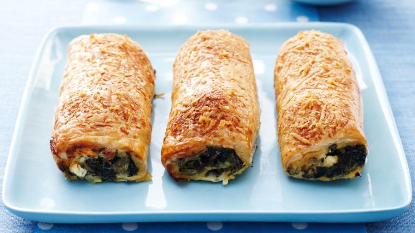 Three vegetarian sausage rolls lay on a blue serving dish.