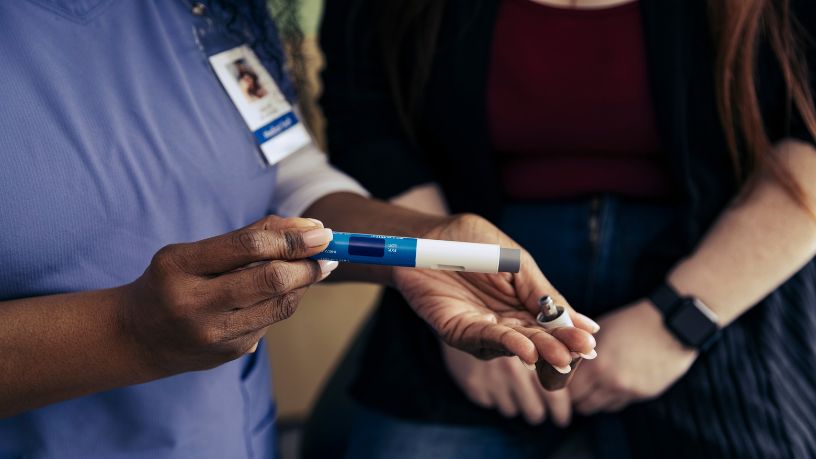 A medical professional showing someone weight loss injections.