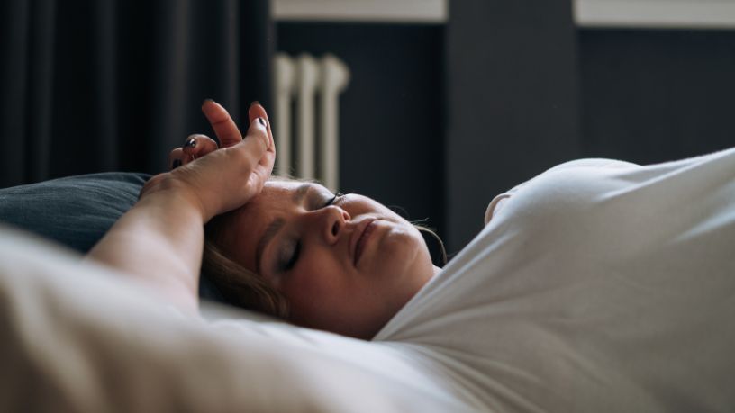 A woman laying down trying to sleep.