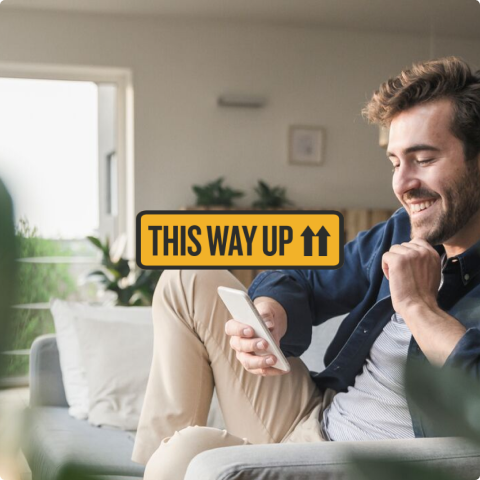 Young person standing at a kitchen bench looking at a tablet
